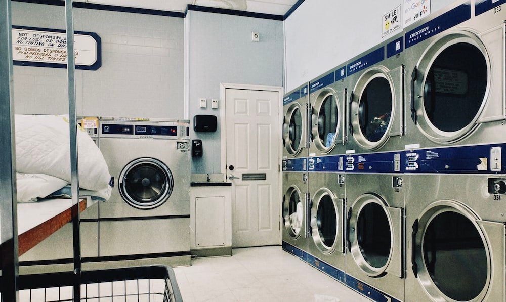 How To Soundproof A Laundry Closet? a row of washers and dryers in a laundry room